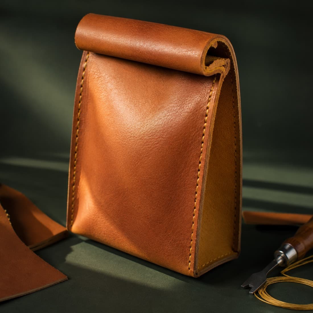 Pouch Full-Grain photographed closed on a deep green ground
